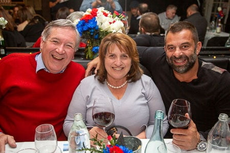 Three guests toasting with red wine at Cup and Cook's event.